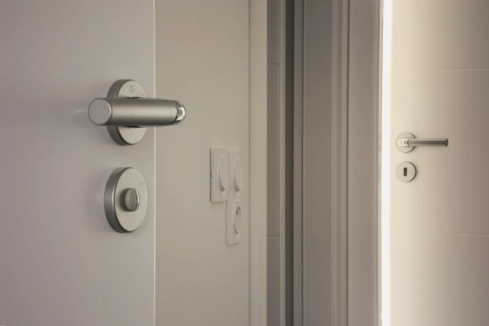 Vue d'une porte avec focus sur la poignée avec des matérieux de qualité. Projet réalisé par Hauplo